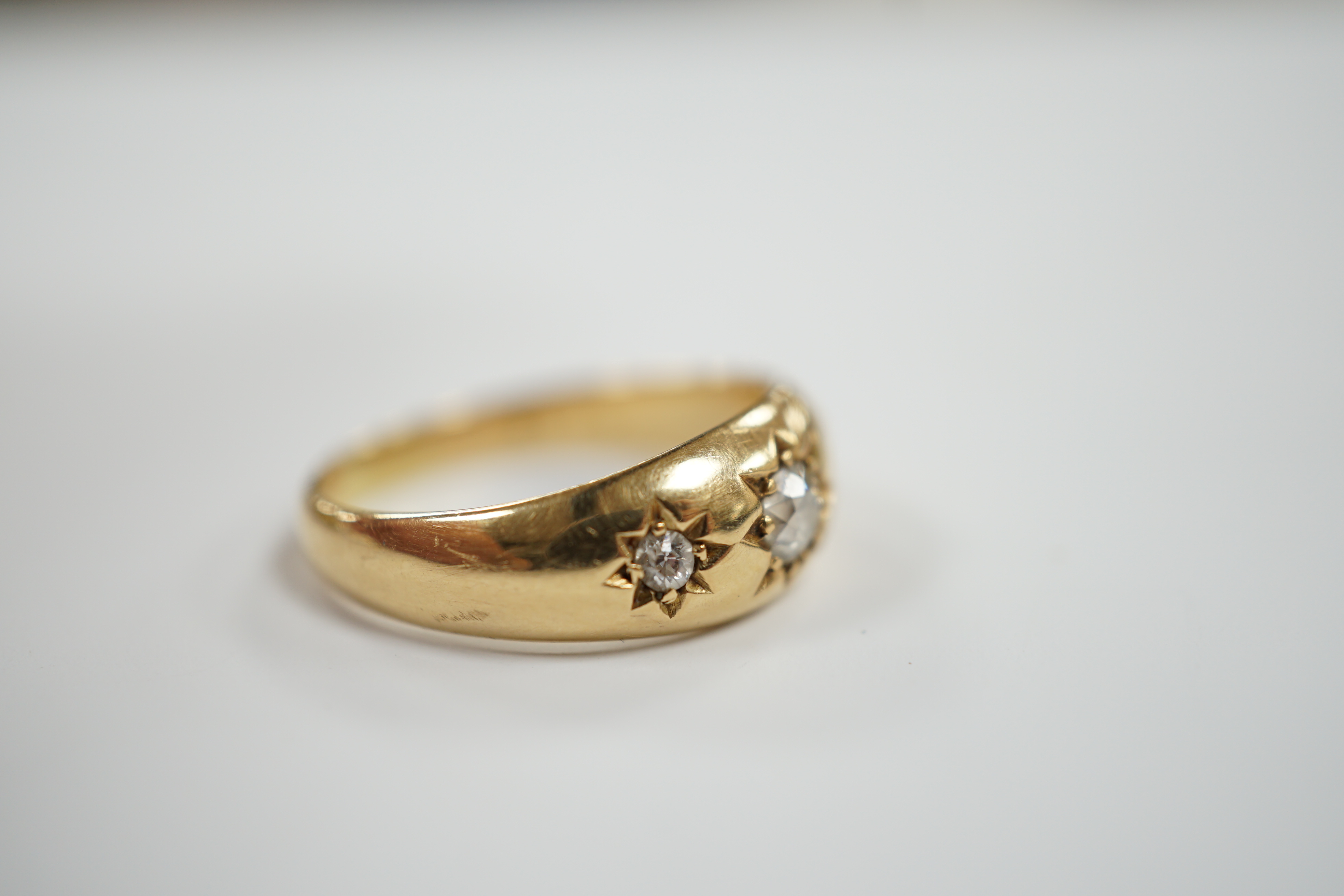 An Edwardian 18ct gold and gypsy set three stone diamond ring, size Q, gross weight 6.3 grams.